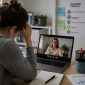 A remote employee appearing stressed during a virtual meeting, highlighting psychosocial risks and mental health challenges in remote and hybrid work environments.